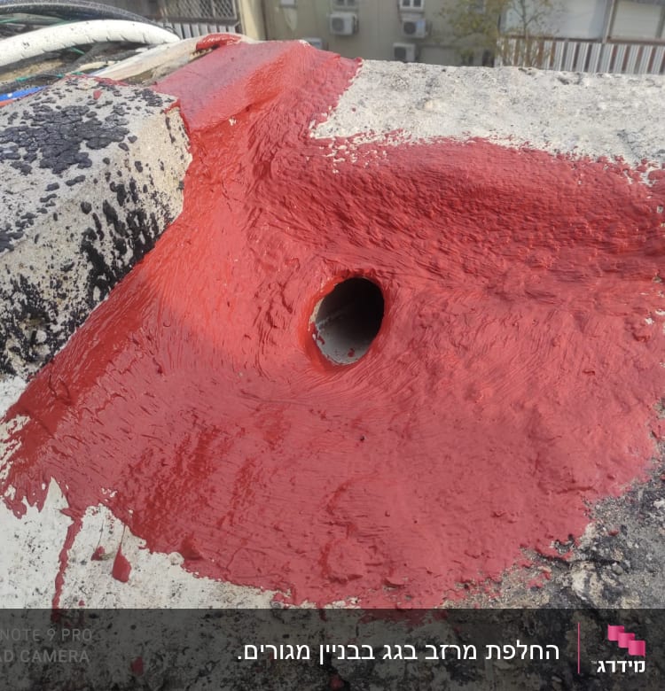 צינור על גג עם איטום אדום סביבו